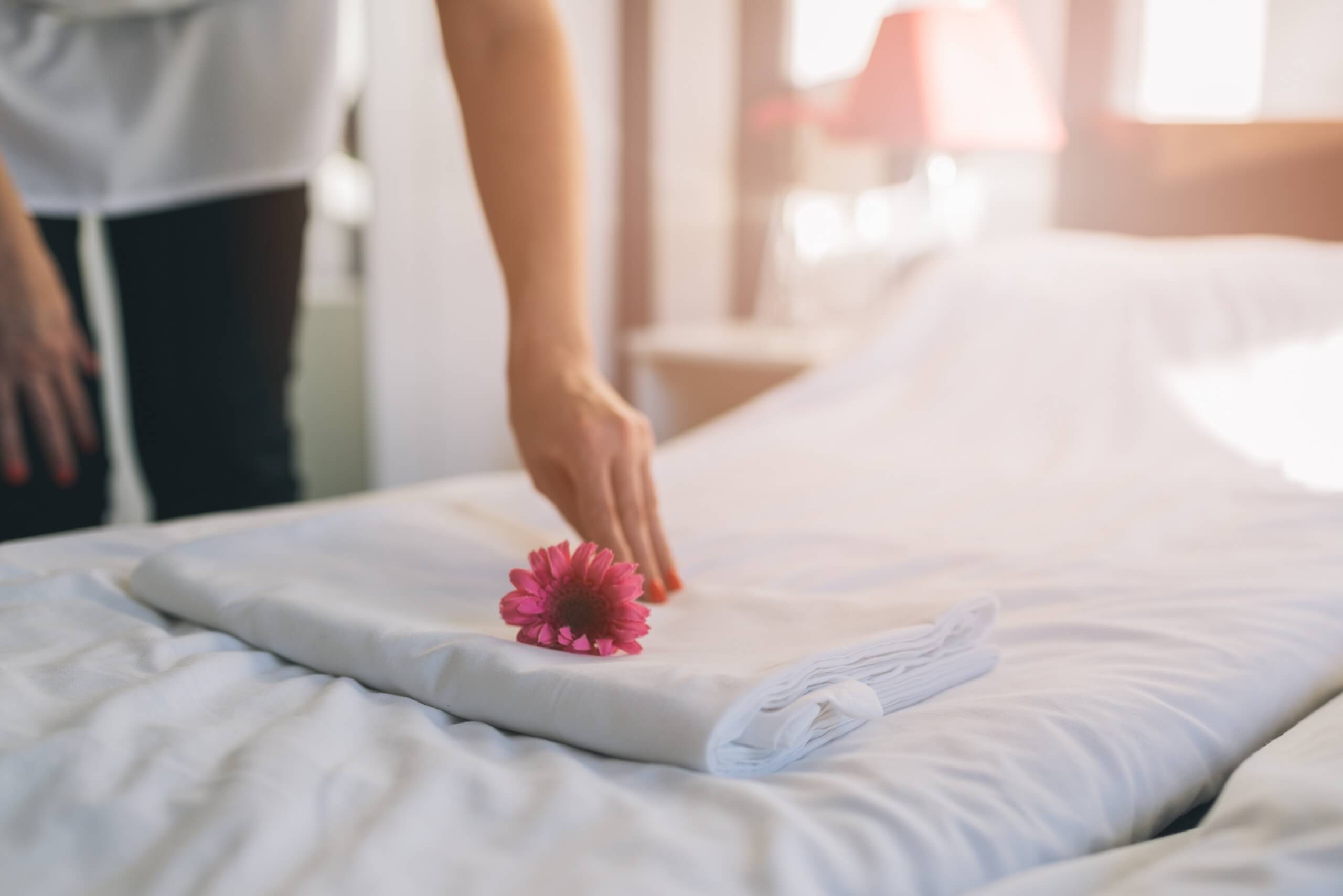 Housekeeper finishing touch bed